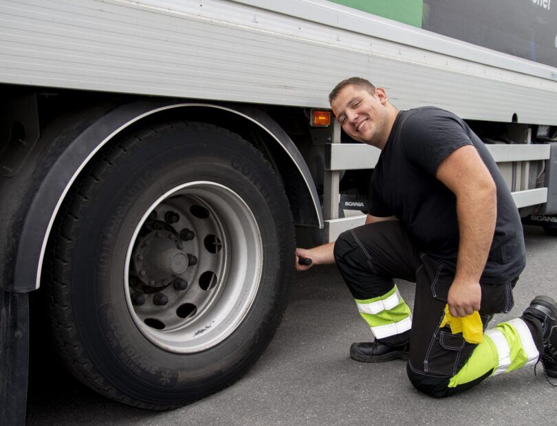 En man som kontrollerar hjulen på en lastbil